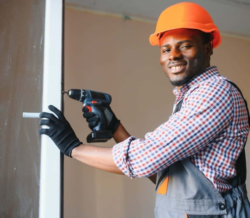 african american workman in overalls installing